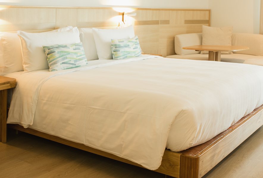 Made bed with white linens in a guest room